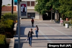 FILE - In this Sept. 2, 2020 file photo people walk on campus at San Diego State University, in San Diego. (AP Photo/Gregory Bull,File)