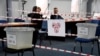 Kosovo electoral commission staff sit at a polling station in the town of Zvecan on April 21, 2024.