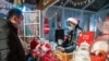 上海一名小販在平安夜一家購物中心外的聖誕主題市場上向顧客售賣飲料。（2020年12月24日）