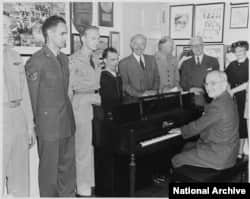 President Truman playing the piano in the White House
