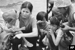 FILE - In this April 29, 1975 file photo, a South Vietnamese mother and her three children are shown on the deck of a ship being taken out of Saigon by U.S. Marine helicopters in Vietnam.