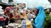 Une femme achète des denrées alimentaires dans un marché de rue à Abobo, en Côte d'Ivoire, le 9 juillet 2013.
