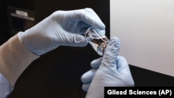 In this March 2020 photo provided by Gilead Sciences, a vial of the drug remdesivir is visually inspected at a Gilead manufacturing site in the United States. (Gilead Sciences via AP)