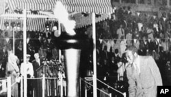 Prime Minister Robert Mugabe of the newly independent state of Zimbabwe, lights the Independence Flame, April 18, 1980, which is to burn eternally as a monument to black majority rule won through seven years of guerrilla warfare and political effort.