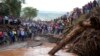 People gather on a bridge where a woman's body was retrieved after floodwater washed away houses and people in Kamuchiri village, Nakuru county, Kenya, on April 30, 2024. At least 48 people were killed in the incident.