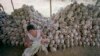 FILE - A man cleans a skull near a mass grave at the Chaung Ek torture camp run by the Khmer Rouge in this undated photo. 