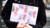 Человек держит фото семьи Навальных на акции памяти политика в Берлине, 16 февраля 2024