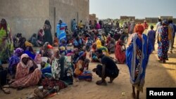 (FILE) Sudanese refugees gather as Doctors Without Borders teams assist the war-wounded from West Darfur.