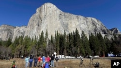 Spectators look at El Capitan for a glimpse of climbers Tommy Caldwell and Kevin Jorgeson on Wednesday, Jan. 14, 2015, as seen from the valley floor in Yosemite National Park, Calif. Caldwell and Jorgeson became the first to free-climb the rock formation'