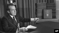 FILE - President Richard M. Nixon is shown pointing to the transcripts of the White House tapes in this Apr. 29, 1974 photo, after he announced during a nationally-televised speech that he would turn over the transcripts to House impeachment investigators.