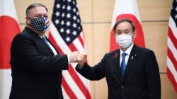 Japan's Prime Minister Yoshihide Suga, right, and U.S. Secretary of State Mike Pompeo, left, greet prior to their meeting at the prime minister's office in Tokyo, Tuesday, Oct. 6, 2020. (Charly Triballeau/Pool Photo via AP)