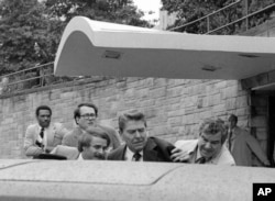 FILE - U.S. President Ronald Reagan waves and then looks up before being shoved into the President's limousine by secret service agents after being shot outside a Washington hotel Monday, March 30, 1981. (AP Photo/Ron Edmonds)