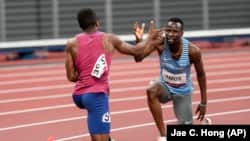 Isaiah Jewett, of the United States, and Nijel Amos, right, of Botswana, shake hands after falling in the men's 800-meter semifinal at the 2020 Summer Olympics, Sunday, Aug. 1, 2021, in Tokyo.