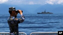 中國軍隊圍繞台灣島舉行的軍演期間，一名中國海軍士兵從軍艦上觀察台灣海軍蘭陽號飛彈巡防艦。 （2022年8月5日）