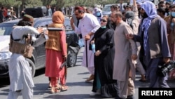 جنگجوی طالبان زنی را در جریان یک تظاهرات در کابل با اسلحه تهدید می‌کند - آرشیو