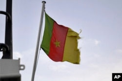 A Cameroonian flag flies on a ship at the port in Douala, Cameroon, on April 10, 2022. (AP Photo/Grace Ekpu)