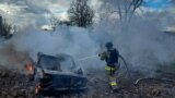 资料照片：乌克兰尼古拉耶夫市一名消防人员在俄罗斯导弹攻击后给一辆汽车灭火。(2024年3月17日）