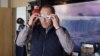 Niagara Falls Mayor Jim Diodati poses with a pair of solar eclipse safety glasses at his office