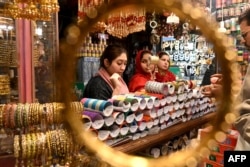 لاہور میں چوڑیوں کی ایک دکان پر خواتین چوڑیاں بیچ رہی ہیں ، فوٹو اےایف پی ، 7 اپریل 2024