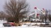 FILE - Utility workers from Xcel Energy tend to power lines near a home destroyed by the Smokehouse Creek fire on Feb. 29, 2024, in Stinnett, Texas. Xcel said on March 7 that its facilities appeared to have played a role in igniting the massive wildfire.