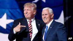 Republican presidential candidate Donald Trump, points toward Republican vice presidential candidate Indiana Gov. Mike Pence after Pence's acceptance speech