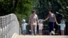 资料照片：两名中国妇女带着孩童走在北京街头。(2017年6月1日)