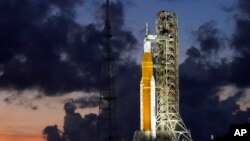 ARCHIVO - El cohete Artemis I de la NASA con la nave espacial Orion a bordo se ve en la plataforma 39B justo después del atardecer en el Centro Espacial Kennedy, en Cabo Cañaveral, Florida, el 27 de junio de 2022.