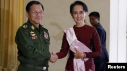 FILE - Senior General Min Aung Hlaing, Myanmar's commander-in-chief, shakes hands with National League for Democracy party leader Aung San Suu Kyi before their meeting in Hlaing's office at Naypyitaw Dec. 2, 2015.