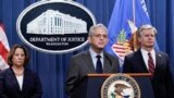 Attorney General Merrick Garland, center, flanked by Deputy Attorney General Lisa Monaco, left, and FBI Director Christopher Wray, speaks to reporters as they announce charges against two men suspected of being Chinese intelligence officers. (October 23, 2022)