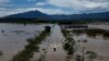 Residentes cruzan una carretera sumergida en un bote después de una lluvia mortal en Duque de Caxias, Brasil, el 15 de enero de 2024.
