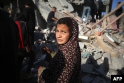 وسطی غزہ میں 10 جنوری 2024 کو ایک اسرائیلی حملے کے بعد ایک فلسطینی لڑکی ایک مکان کے ملبے کے سامنے غمزدہ کھڑی ہے ، فوٹو اے ایف پی