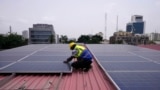 Oladapo Adekunle, an engineer with Rensource Energy, installs solar panels on a roof of a house in Lagos, Nigeria, Thursday, March 21, 2024. (AP Photo/Sunday Alamba)