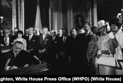 Until civil rights laws, many schools, businesses, and public buildings such as libraries and pools were segregated by race. Here, Johnson signs the Civil Rights Act of 1964. Martin Luther King, Jr. and other leaders look on. (Cecil Stoughton/The White House)
