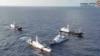 菲律賓海岸警衛隊2024 年3月23 日發布的空拍影片截圖顯示，一艘中國海岸警衛隊船隻（左二）和「中國海上民兵」的船隻（左和右）包圍了在第二托馬斯淺灘附近海域 執行補給任務的菲律賓海岸防衛隊船隻BRP Cabra（右二）。