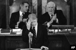 FILE - President Jimmy Carter touches his brow as he addresses those in the House chamber of the Capitol in Washington on Jan. 23, 1979. (AP Photo)