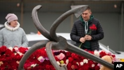 俄罗斯居民在莫斯科地区发生恐怖攻击的音乐厅附近的临时记念场所献花。