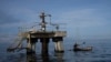 Un pescador navega frente a una perforadora petrolera fuera de operaciones en el lago Maracaibo en Venezuela, a principios del 12 de octubre de 2022. 