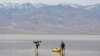 Jay Coley, left, and Dede Barney, both of St. George, Utah, are on Lake Manly, a temporary lake formed by heavy rain, at Death Valley National Park, California, Feb. 24, 2024. The lake is located at Badwater Basin, the lowest point in North America at 282 feet below sea level.