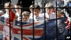 Students embrace at a floral tribute at the Botanical Gardens in Christchurch, New Zealand, March 19, 2019.