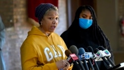 Cheri Warner, left, stands with her daughter, Brea, and speaks calling for the Chicago school district and teacher's union to focus on getting students back in the classroom Monday, Jan. 10, 2022, in Chicago. (AP Photo/Charles Rex Arbogast)