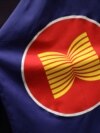 Seorang pekerja membenahi letak bendera ASEAN di sebuah aula pertemuan di Kuala Lumpur, Malaysia, 28 Oktober 2021. (Photo: REUTERS/Lim Huey Teng)