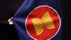 Seorang pekerja membenahi letak bendera ASEAN di sebuah aula pertemuan di Kuala Lumpur, Malaysia, 28 Oktober 2021. (Photo: REUTERS/Lim Huey Teng)