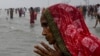 ایک ہندو یاتری خاتون کلکتہ کے قریب دریائے گنگا کے پانی سے منہ دھو رہی ہے۔ ہندوؤں کے عقیدے میں یہ مقدس پانی ہے جس میں بیماریوں سے شفا موجود ہے۔ 14 جنوری 2022
