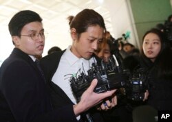 K-pop singer Jung Joon-young, center, arrives at the Seoul Metropolitan Police Agency in Seoul, South Korea, March 14, 2019.