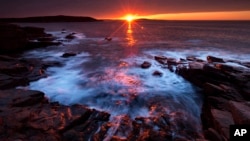 The sun's rays strike the rocky coast of Acadia National Park, in Maine, May 2, 2013. 