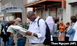 A mechanical engineering graduate student reads a newspaper at the University of Texas in Austin, Texas.