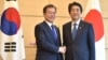 South Korea's President Moon Jae-in, left, shakes hands with Japan's Prime Minister Shinzo Abe before their meeting at Abe's official residence in Tokyo, May 9, 2018. 