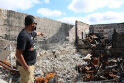 Ruhel Islam, owner of Gandhi Mahal Restaurant, which was burned in rioting after George Floyd's death at the hands of Minneapolis police, shows where the kitchen use to be in his restaurant. (K. Khan/VOA)