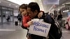Thy Chea, of Lowell, Mass., center right, originally of Cambodia, hugs his daughter on his arrival at Boston's Logan Airport, Wednesday, Feb. 26, 2020, after getting his green card reinstated last year. 