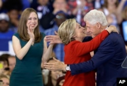FILE - Democratic presidential candidate Hillary Clinton hugs her husband, former President Bill Clinton as their daughter Chelsea Clinton looks on during a campaign rally in Raleigh, N.C., Nov. 8, 2016. (AP Photo/Gerry Broome)